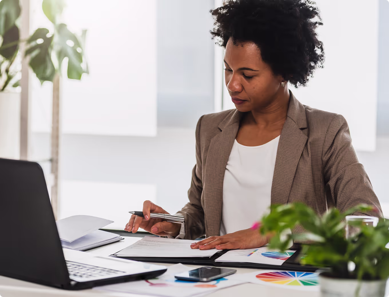 A woman in a brown suit is writing on a piece of paper.