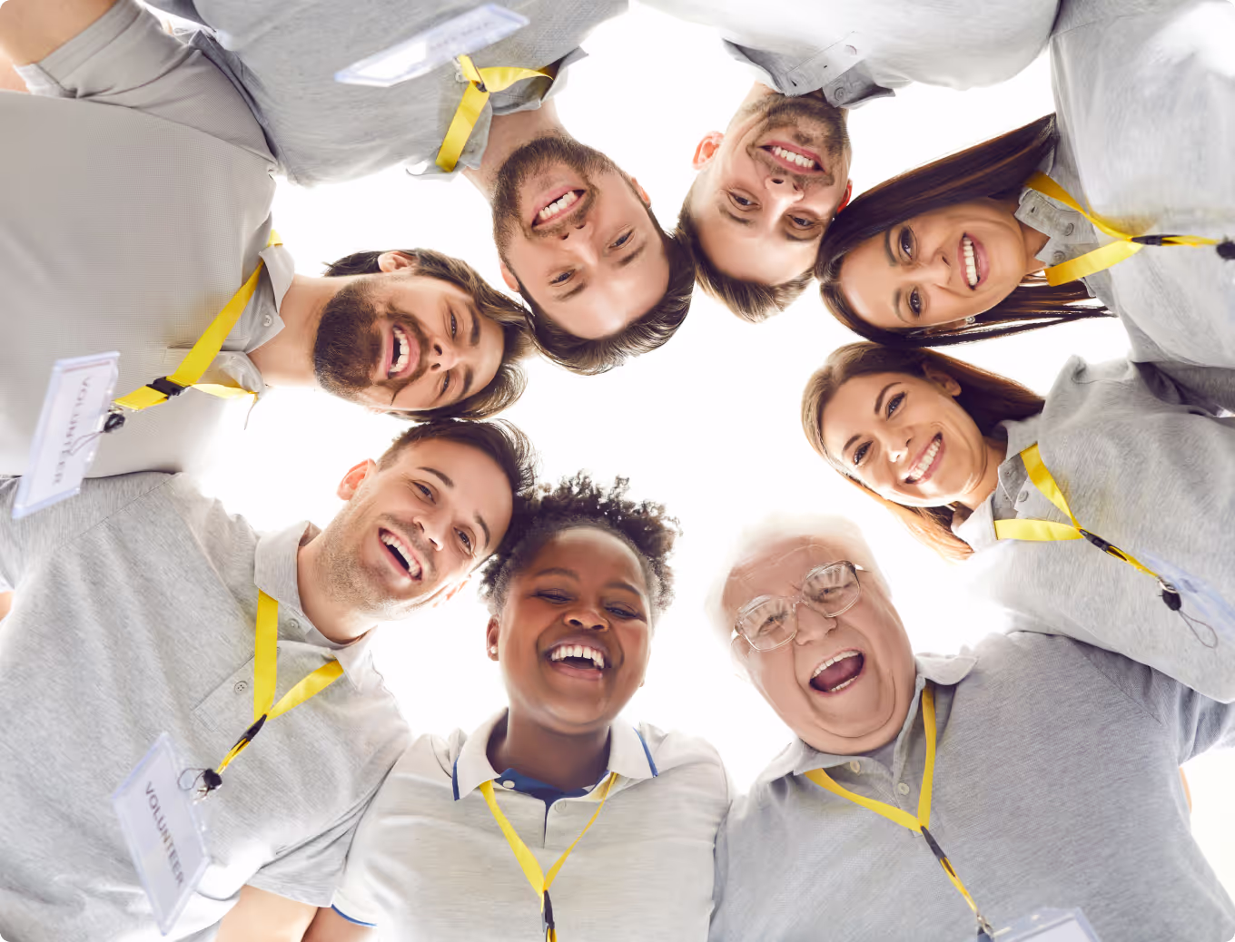 A group of people wearing yellow lanyards and smiling.