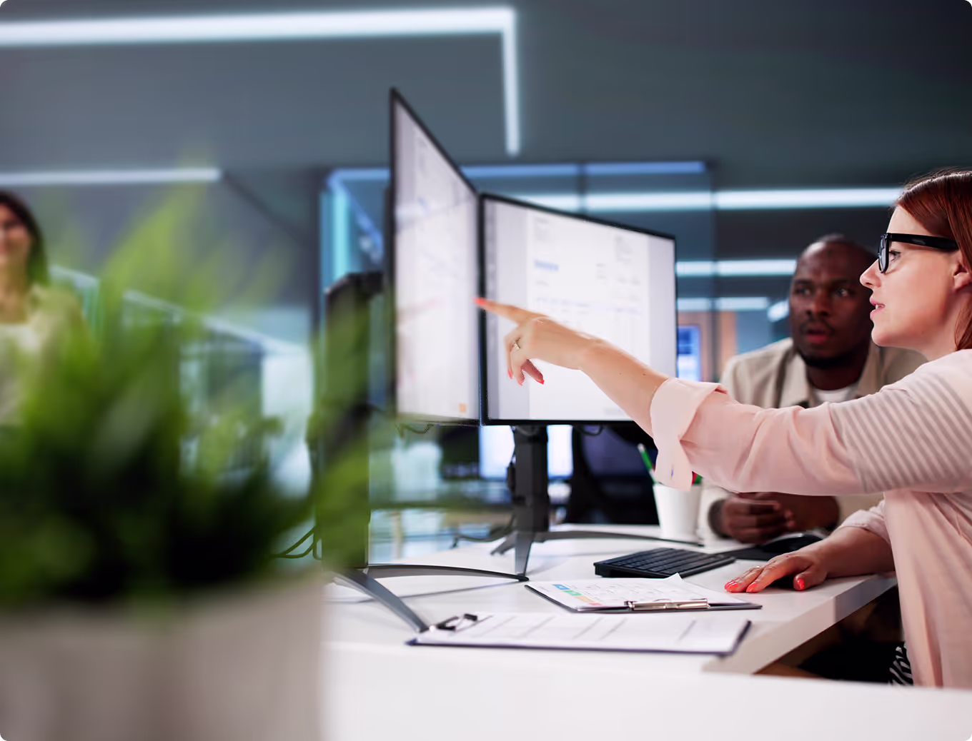 A woman pointing at a computer screen.