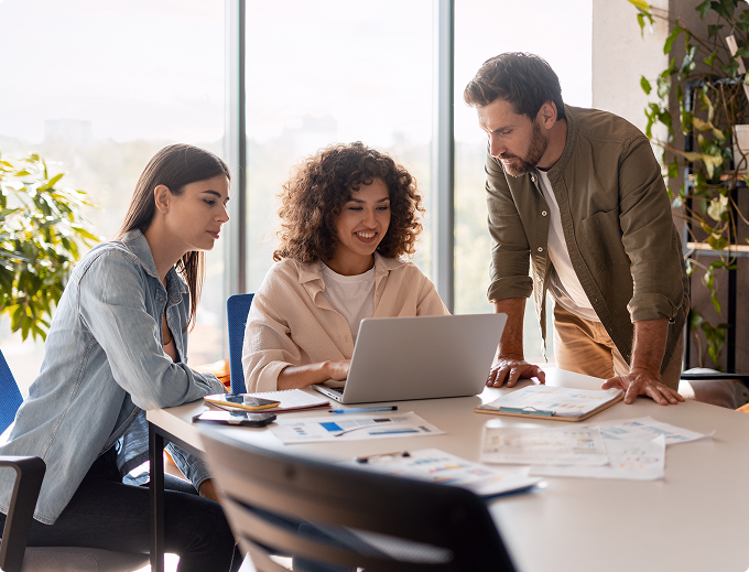 A man and woman are standing in a kitchen, smiling and holding a piece of paper.