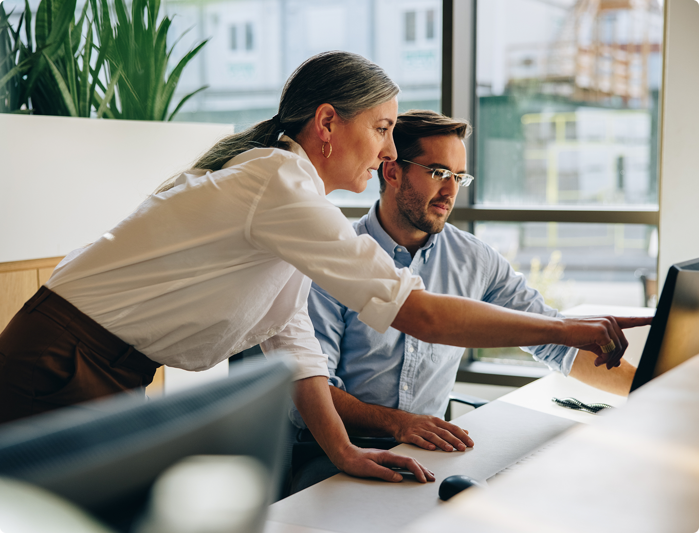 A man and woman are standing in a kitchen, smiling and holding a piece of paper.